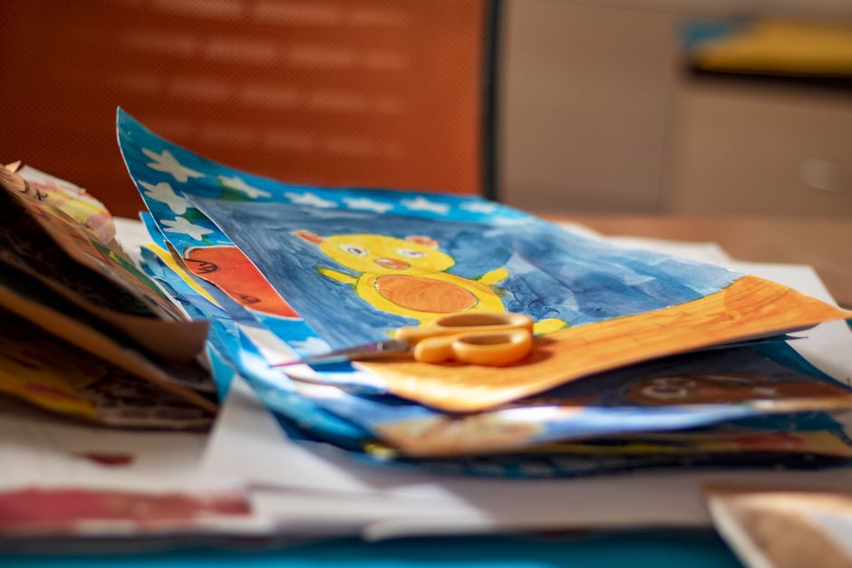 Vibrant children's artwork featuring a yellow bear, surrounded by crafting supplies.