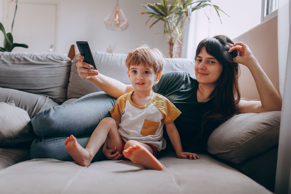 Mother and son enjoying quality time on a comfortable sofa in a cozy living room setting.