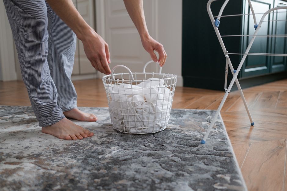 A person organizing laundry in a cozy indoor setting, highlighting domestic chores.
