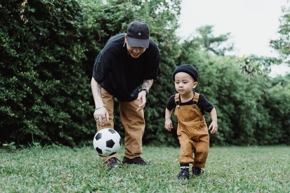 公園でサッカーをする親子