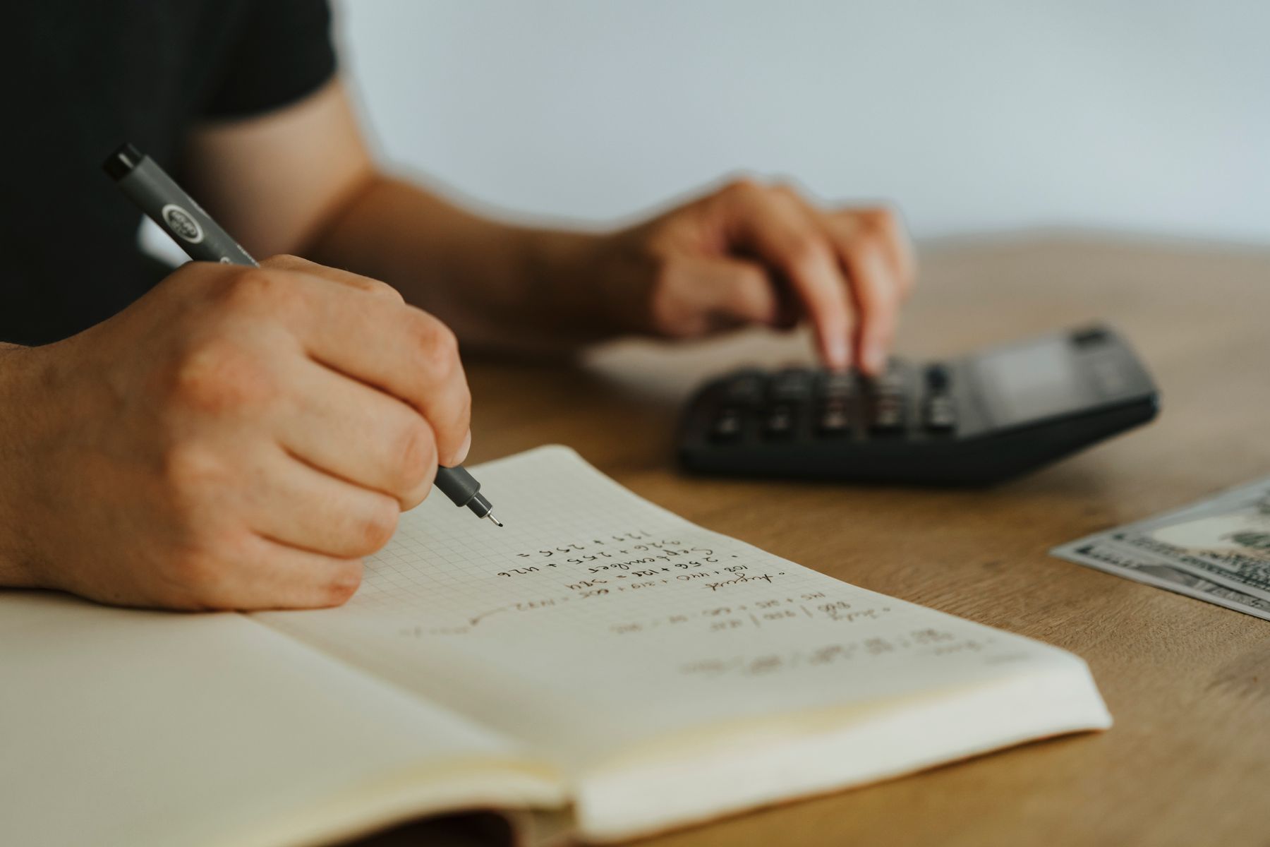ノートに教育費の計画を書き込みながら考える様子