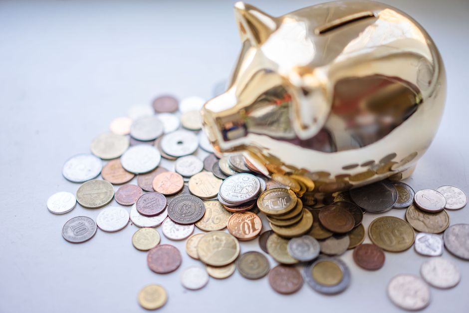 貯金箱と硬貨。子どもの将来のためのお金を考えるイメージ